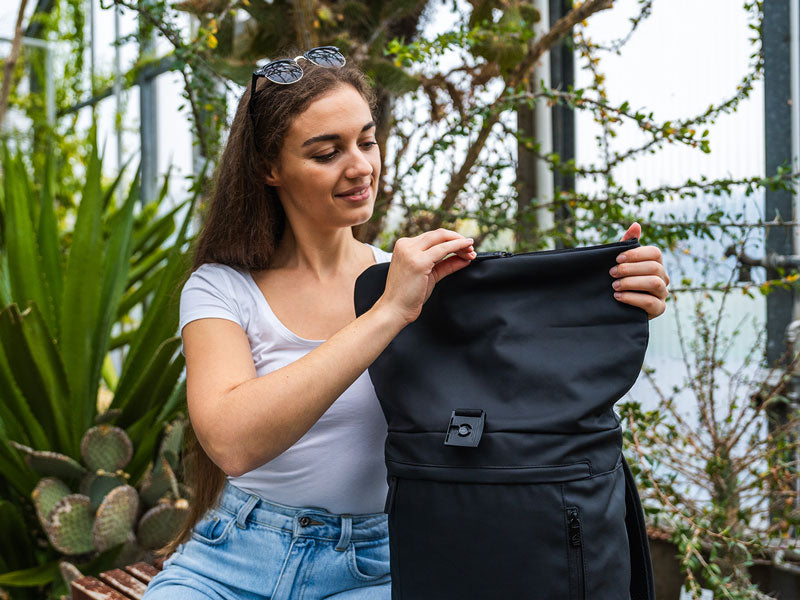 Frau öffnet Stadtrucksack