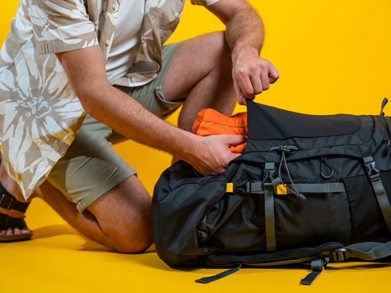 Mann in Hemd packt Backpacking Rucksack