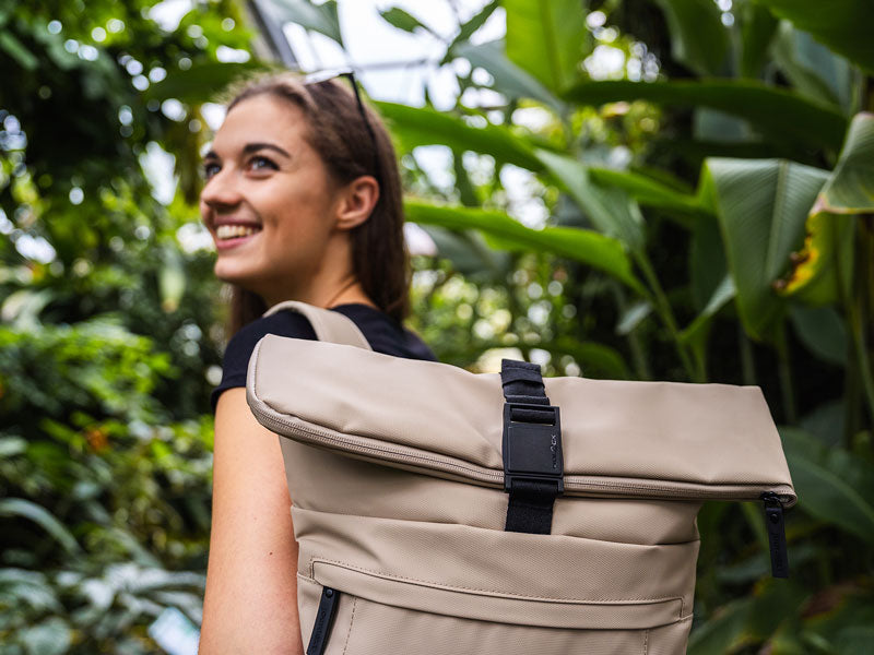 Frau lächelt Rolltop Rucksack