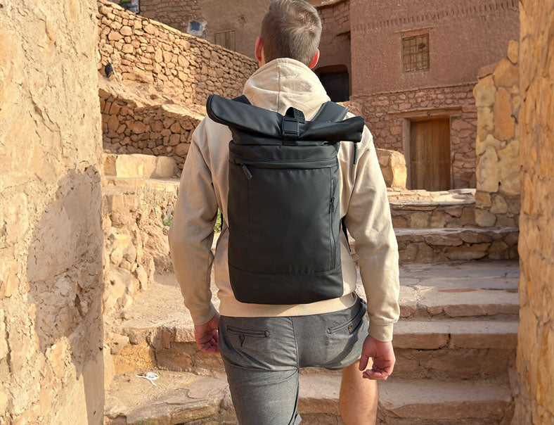 Mann läuft mit schwarzen Rucksack Treppen hoch