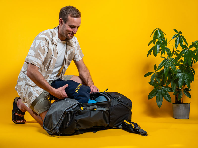 Mann packt Backpacking Rucksack mit Frontloader